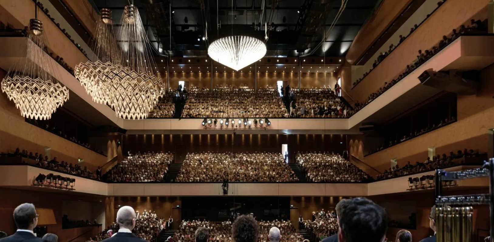 Großer Konzertsaal des Festspielhauses Baden-Baden mit drei Rängen, vollen Sitzreihen und prunkvollen Kronleuchtern